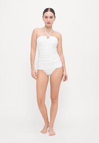 Witte twee-delige bikini met een strapless top met een halternek ontwerp, gathering in het midden, en bijpassende bikinibroekjes.