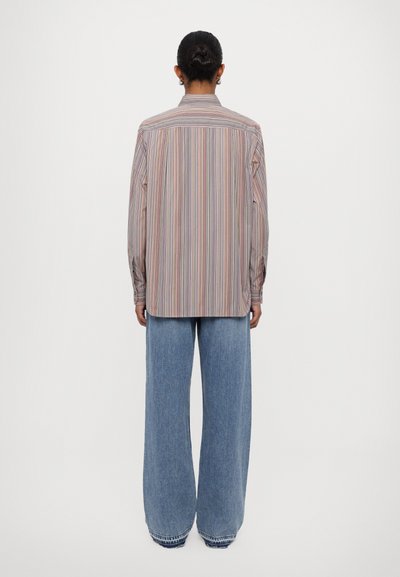 Gestreiftes Langarmhemd in Pastellfarben, mit geradem Schnitt und Knopfmanschetten, kombiniert mit weit geschnittenen blauen Jeans.