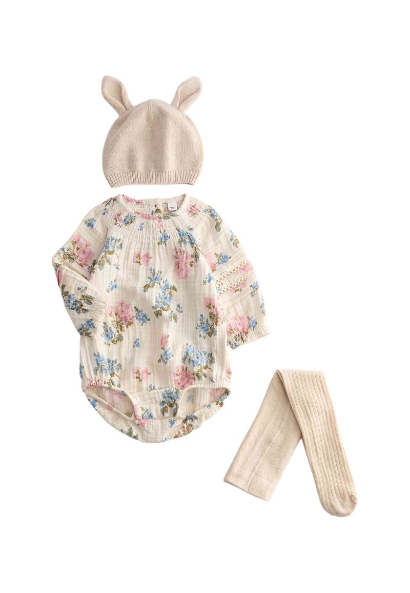 Un body floral de manga larga en color crema con flores azules y rosas, combinado con un gorro de crema con orejas de conejito y leggings de canalé a juego.