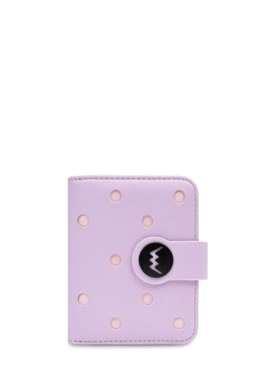 Fialová kožená peněženka s výřezovými puntíky, černé kulaté zapínání se zvlněným designem, kompaktní obdélníkový tvar.