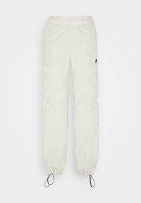 Lätta, krämfärgade cargo-byxor med elastisk midja, dragsko vid bensluten och sidofickor. Strukturerad tygfinish.