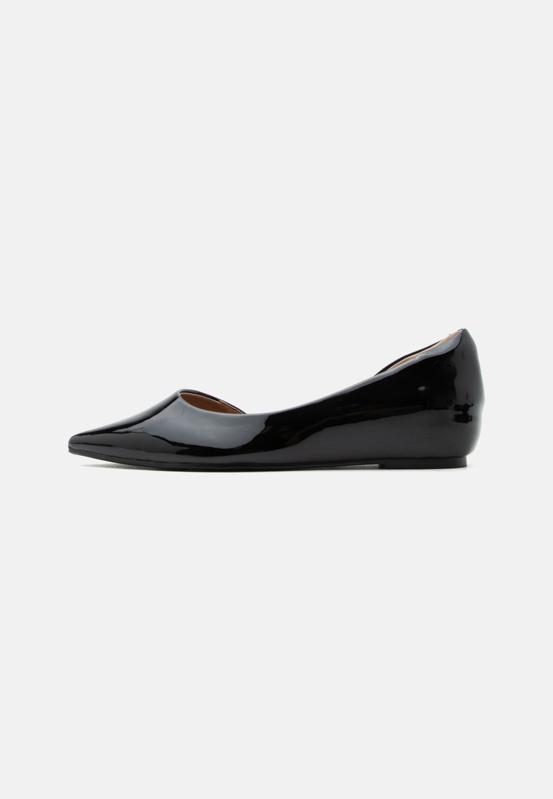 Chaussure plate en cuir verni noir avec bout pointu et petit talon compensé, vue de profil sur fond uni.