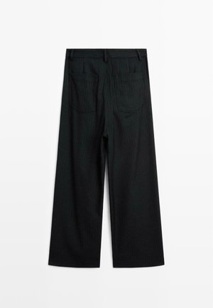 Zwarte broek met streep in wijde pijpen ligt plat, met twee achterzakken en riemlussen op de tailleband.