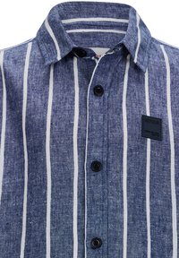Camicia button-up a righe blu e bianche realizzata in tessuto testurizzato, con colletto a punta e bottoni neri, dotata di un'etichetta cucita sulla tasca.