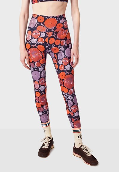 Legíny s fialovým a černým pozadím, zdobené barevným vzorem oranžových a fialových kruhových tvarů. Vysoký pas.