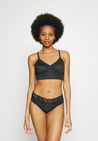 Svart underkläder-set bestående av en ärmlös bralette med spetsdetaljer och matchande trosor med spetsmidja och rosett.