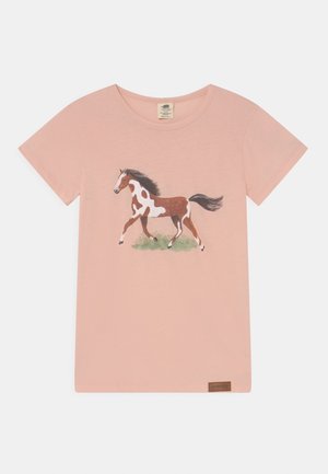 Różowy t-shirt z krótkim rękawem z ilustracją brązowego i białego konia galopującego po zielonej trawie na środku z przodu.