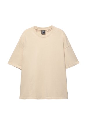 T-shirt oversize beige in cotone, con collo rotondo, maniche corte e un logo discreto impresso sulla parte frontale. Tessuto morbido.