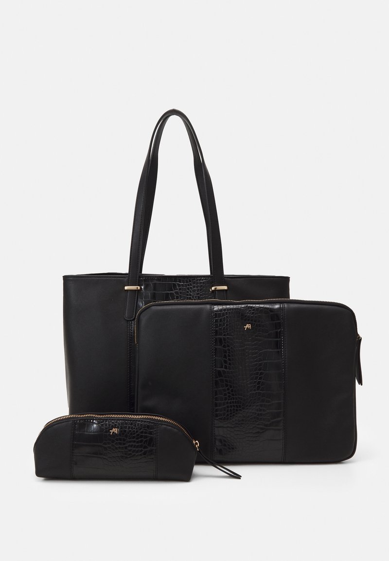 Ensemble de trois sacs noirs comprenant un sac fourre-tout avec de longues anses, une pochette rectangulaire zippée et une petite pochette zippée avec des panneaux texturés.