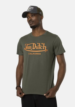 T-shirt en coton vert olive avec logo orange "Von Dutch" et le texte "CALIFORNIA". Manches courtes et col rond, texture de tissu lisse.