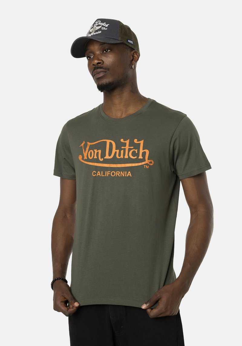 Camiseta de algodón verde oliva con el logo naranja de "Von Dutch" y el texto "CALIFORNIA". Mangas cortas y cuello redondo, textura de tela suave.