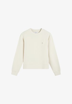 Sudadera de manga larga color crema con cuello redondo, puños y dobladillo acanalados, y un pequeño logo bordado de calavera en el lado izquierdo del pecho.