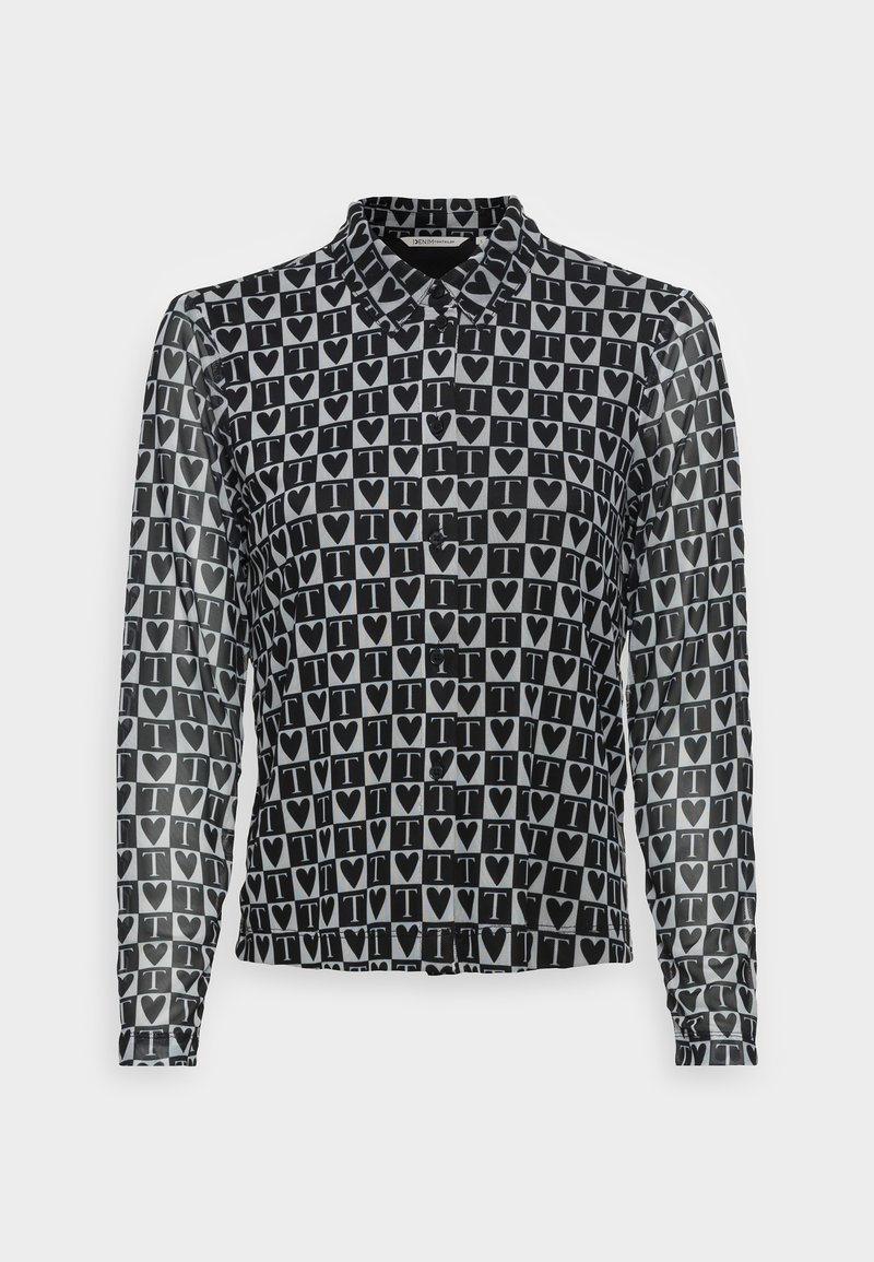 Chemise à manches longues noir et blanc avec un motif répétitif de cœurs noirs et la lettre T à l’intérieur de carrés blancs, boutonnée sur le devant avec col.
