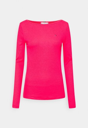 Langærmet skjorte i klar pink, lavet af blødt stof. Har en bred halsudskæring og et lille logo på brystet.