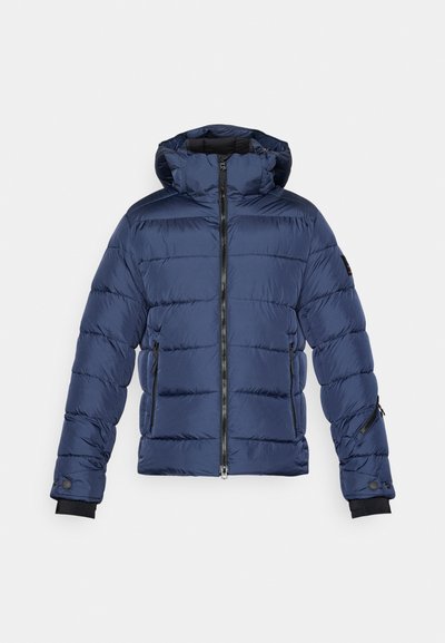 Tamsiai mėlynas puffer tipo švarkas su kapisonu, užtrauktuku priekyje ir dviem šoniniais kišenėmis. Jame yra siuvinėtose dalyse ir guminių rankogalių, kad būtų papildomas šilumos sluoksnis.