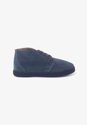 Bottines en suede bleu marine avec bout rond, fermeture à lacets à cinq œillets et semelle en caoutchouc texturé. Design simple et élégant.