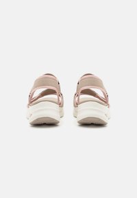 Sandalias ligeras con correas rosas y un acento beige. Presentan un talón abierto y una suela blanca texturizada para mejorar el agarre y la comodidad.