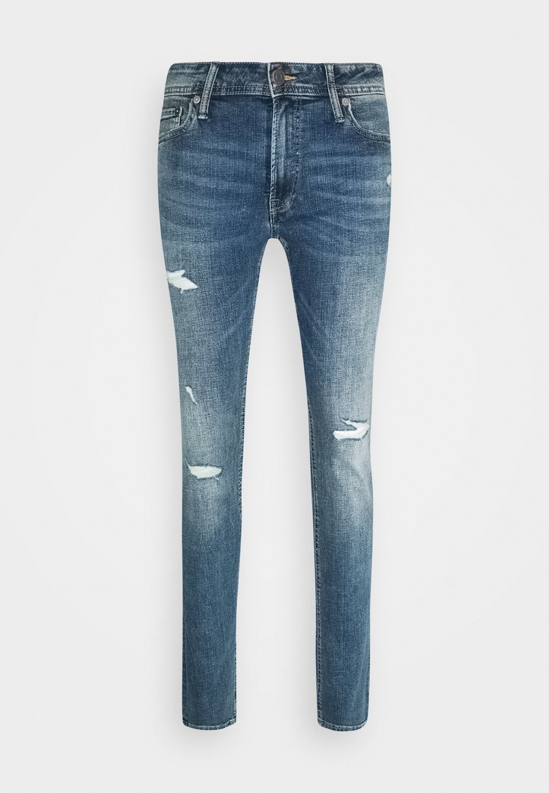 Jeans ajustados de mezclilla azul con un lavado desgastado, parches desgastados en los muslos y las rodillas, botón frontal y diseño de cinco bolsillos.