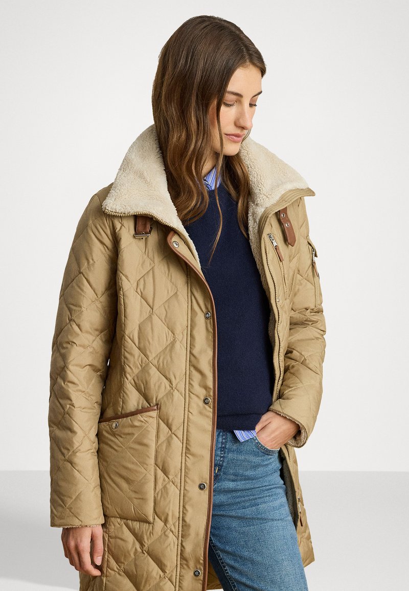 Khaki prešívaná bunda s umelým kožuchom, hnedými akcentmi a bočnými vreckami. Disponuje zipsovým uzáverom a vzorovaným dizajnom.