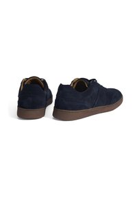 Navy blue suede shoes with a low profile, round toe, brown rubber soles, and simple lace-up design. Features subtle stitching details.