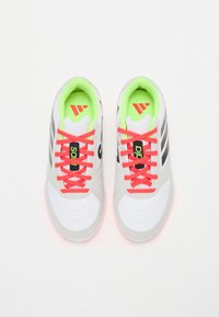 Zapatillas deportivas grises y blancas con parte superior de malla. Los cordones en un brillante color coral y la plantilla de un verde neón presentan el logotipo y las franjas de la marca.