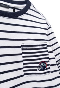T-shirt a righe, bianco e navy, in materiale cotone. Presenta una tasca sul petto con logo ricamato e un design a girocollo. Texture morbida.