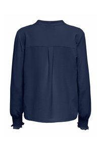 Blouse bleu marine à manches longues avec poignets smockés, empiècement dans le dos et pli creux central, présentée sur fond blanc.