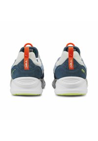 Puma-Sneaker mit einem Obermaterial aus blauem und grauem Wildleder, einer weißen Sohle mit grünen Akzenten und einer leuchtend orangefarbenen Fersenschlaufe.