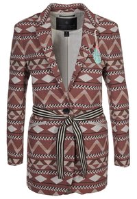 Mönstrad kavaj i röda nyanser med geometriska mönster, enstaka knappstängning och ett svart-vitt randigt bälte. Tillverkad av texturerat tyg.