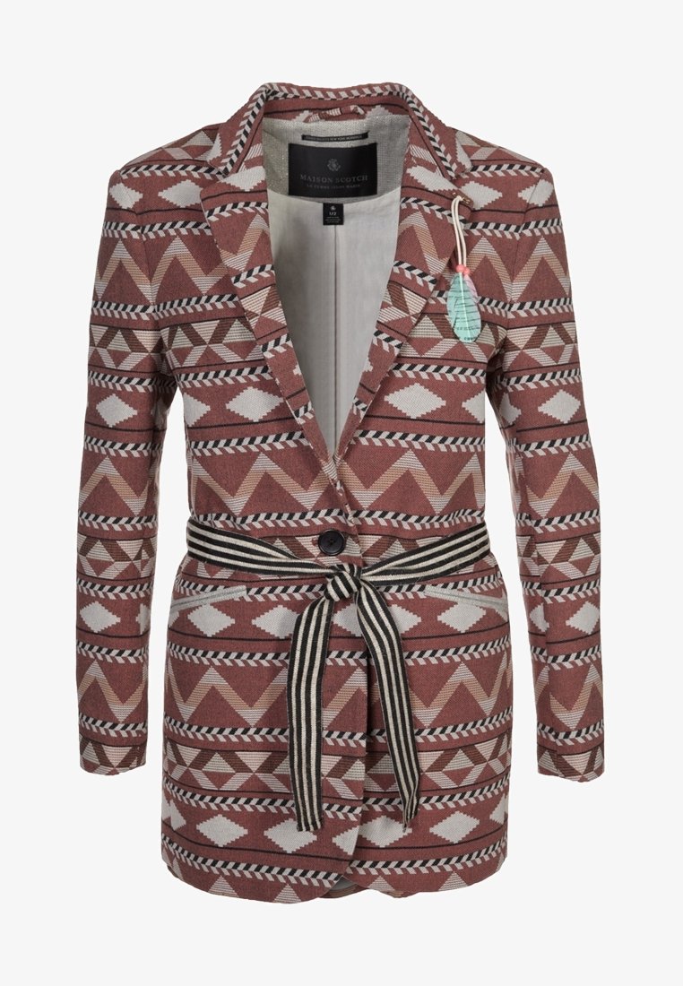 Mönstrad kavaj i röda nyanser med geometriska mönster, enstaka knappstängning och ett svart-vitt randigt bälte. Tillverkad av texturerat tyg.