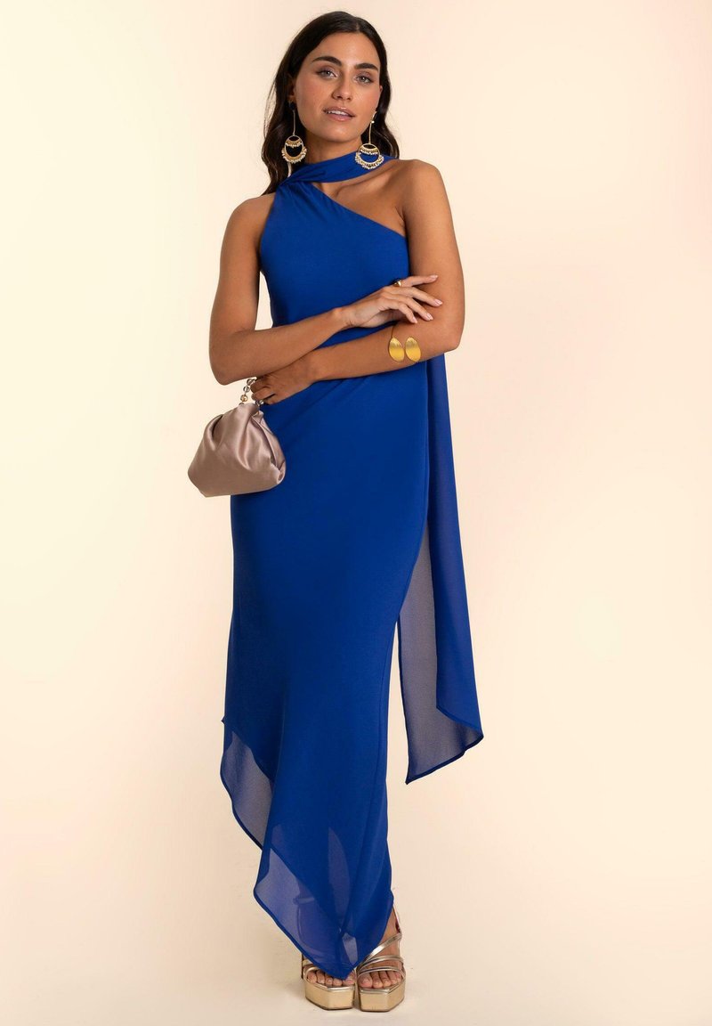 Royalblaues, einseitiges Kleid mit fließendem Design, das einen hohen Schlitz und durchsichtige Textur aufweist. Kombiniert mit goldenen Absatzsandalen und einer beigen Clutch.