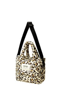 Leopard print handbag with padded exterior, two short handles, and a long adjustable black strap. Features a white label with text.