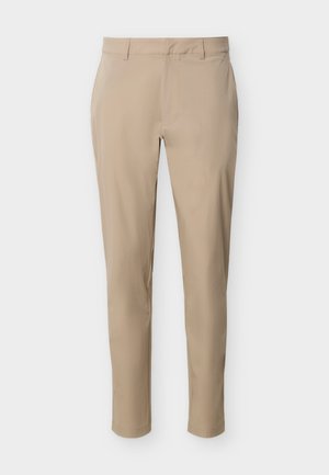 Pantalones beige de corte ajustado con trabillas para cinturón, cremallera frontal y bolsillos, presentados sobre un fondo claro.