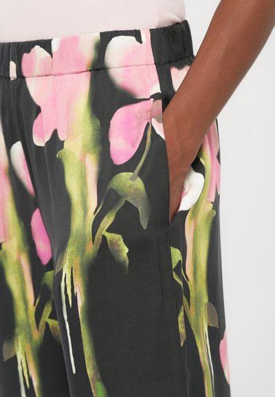 Black fabric pants featuring a floral design with pink and green accents. Includes side pockets and an elastic waistband.