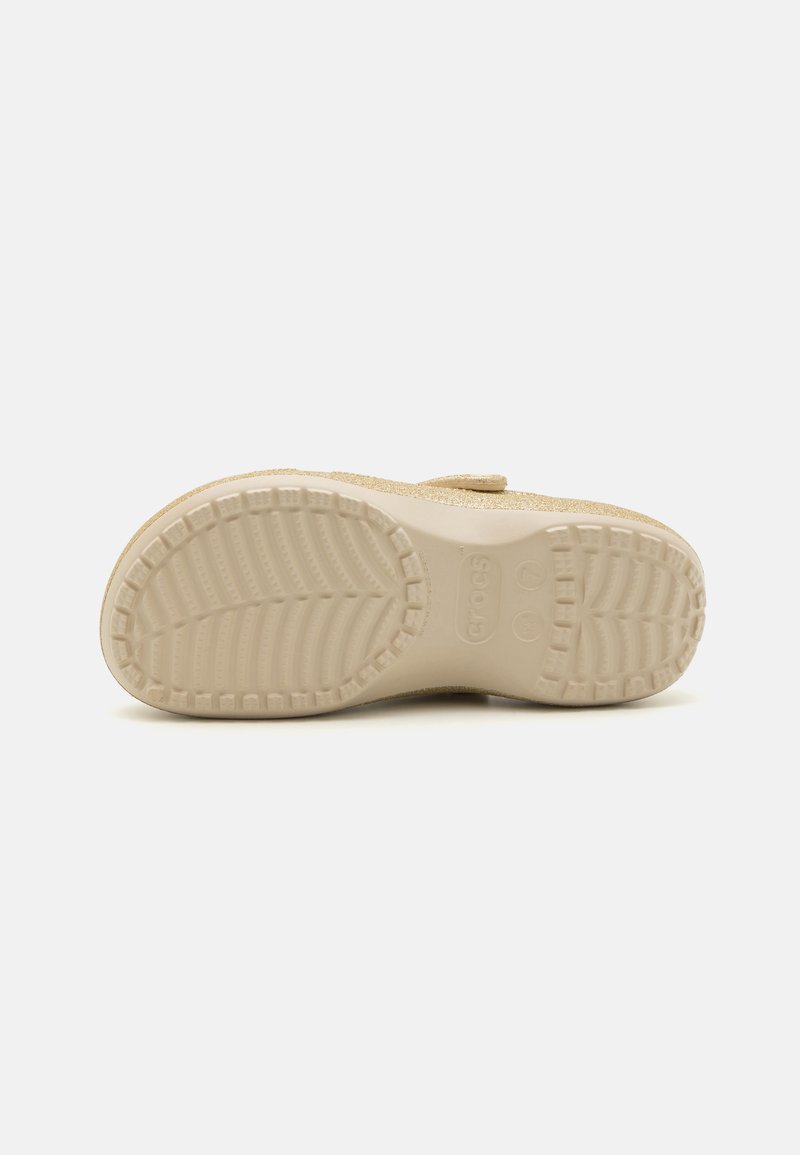 Suela de una bota Crocs beige que presenta un patrón de banda de rodadura texturizado, perfil plano y un acabado suave con un ligero brillo.