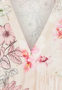 Blommönstrad tyg i mjuk beige, med rosa och röda blommor. V-ringad design med samlad detalj vid fållen. Subtil bladbakgrund.