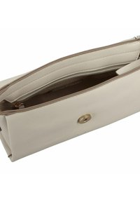 Sac à main en cuir beige avec une texture lisse, fermeture éclair en haut, quincaillerie dorée et un système de fermeture à bouton distinctif. L'intérieur comporte une poche zippée.