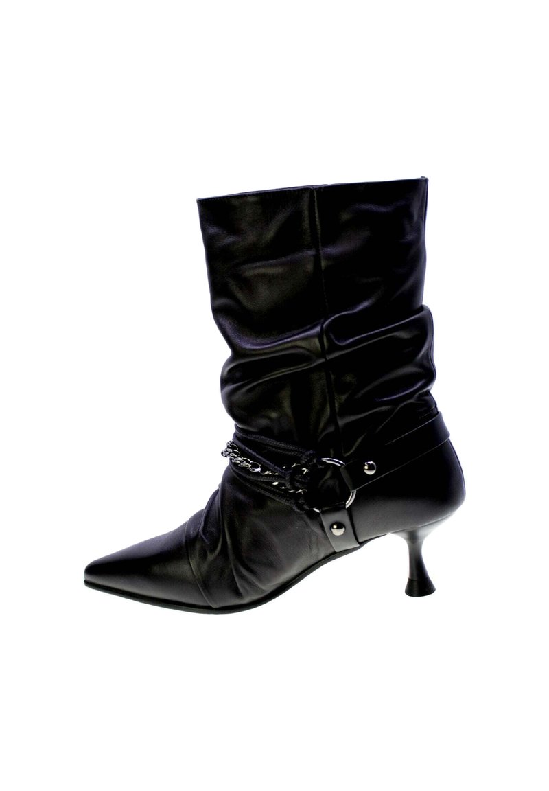 Stivale alla caviglia in pelle nera con design morbido, punta affusolata e tacco alto slim. Presenta un accento a catena attorno alla caviglia con un dettaglio in fibbia.