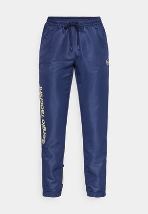 Tamno plave trenirke s remenom za zatezanje u struku, elastičnim manžetnama i zlatnim logotipom duž lijeve strane. Izrađene od glatkog, laganog materijala.