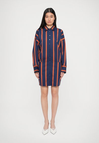 Knoop-jurk in nachtblauw met oranje verticale strepen. Lange mouwen, kraaghalslijn en een rechte pasvorm met een lengte tot op de knie.