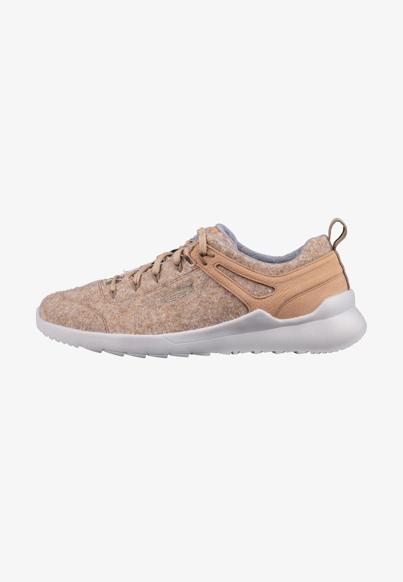 Beige Sport Schuhe mit einer Oberseite aus Filz, grauem Kragen und weißer Sohle; verfügt über ein Schnürdesign und seitliche Akzente für Atmungsaktivität.