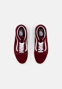 Burgunderfargede semskede sneakers med hvite lisser og sidestripe. Rund tå og gummisåle. Logo på tungen. Ovenfra.