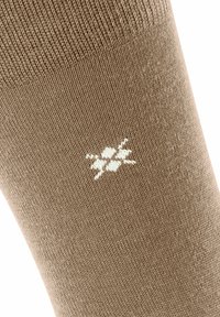 Brązowa bawełniana skarpeta z białym geometrycznym wzorem logo u góry. Tekstura jest gładka, a ściągacz prążkowany dla większego komfortu.