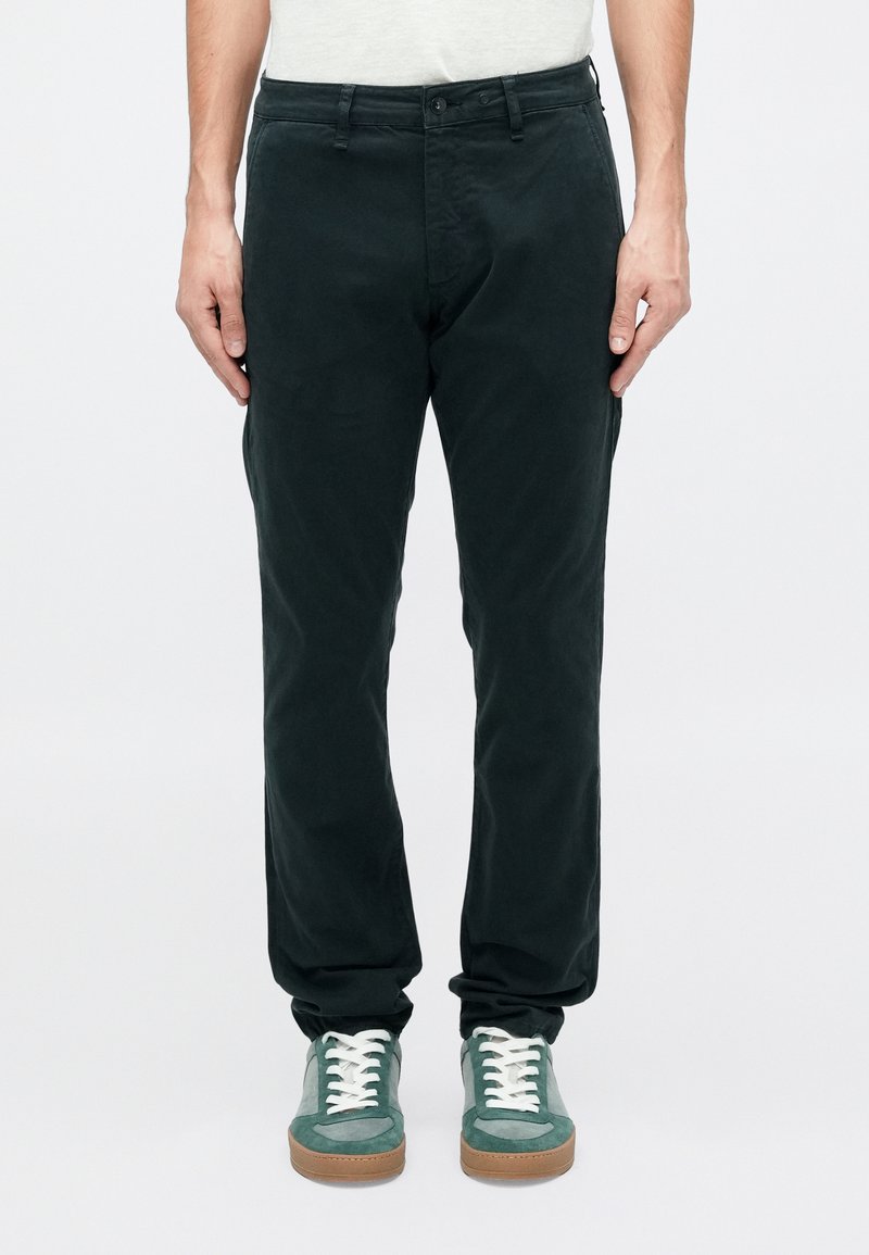 Tamsiai žali medvilniniai chino kelnės su tiesiu kirpimu, turinčios užtrauktuko užsegimą su mygtuku ir dvi priekinės kišenės.