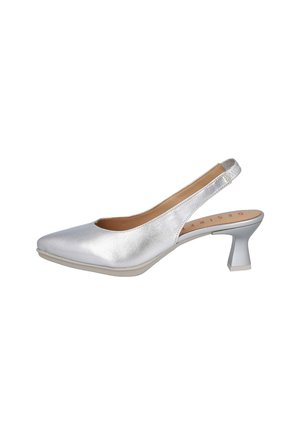 Zapato de salón plateado con tira trasera, punta puntiaguda, tacón bajo curvado y plantilla acolchada beige sobre fondo blanco.