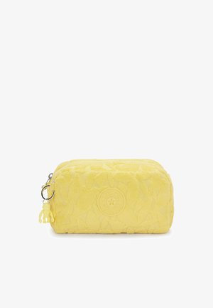 Pochette cosmetica gialla con un motivo floreale testurizzato, chiusura con zip, hardware argentato e un portachiavi a forma di scimmia rimovibile.