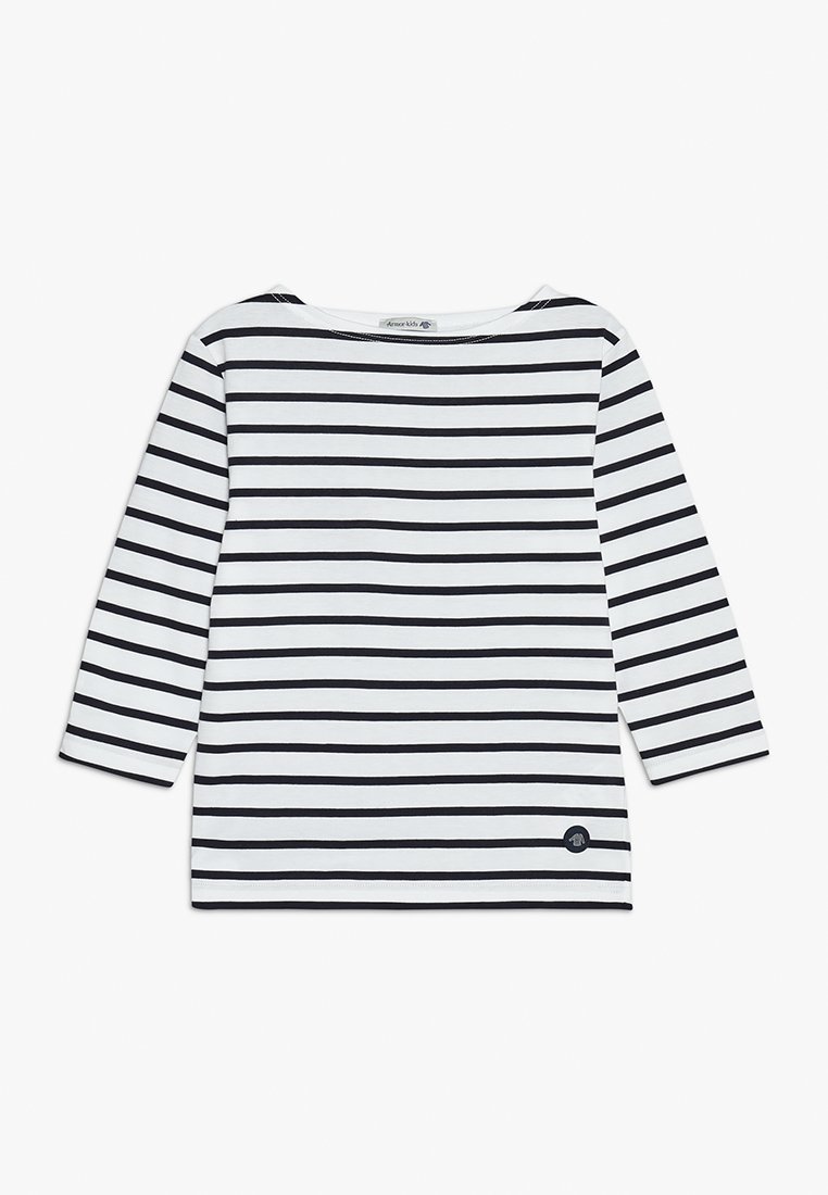 Chemise à manches longues rayée en blanc et noir avec un col bateau et un écusson à logo bleu marine. En coton, coupe décontractée, et ourlet plat.