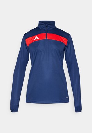 Temno modra športna puloverica z rdežim panelom čez ramena, polovičnim zadrgo, dolgimi rokavi in detajlom logotipa na levi strani.