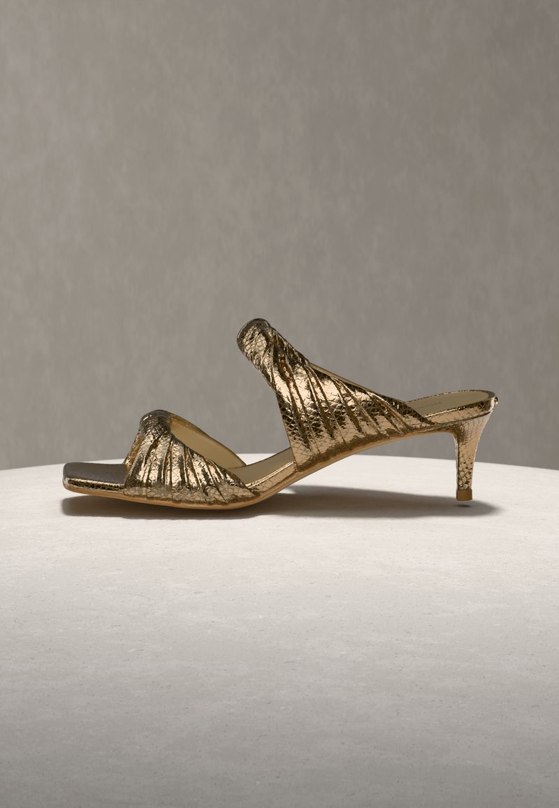 Μεταλλικές χρυσές σανδάλες με υφασμένο επάνω μέρος που διαθέτει πλισέ σχεδιασμό και λεπτό ψηλό τακούνι, παρουσιάζοντας ανοιχτό δάχτυλ ο και πλαϊνές εγκοπές.