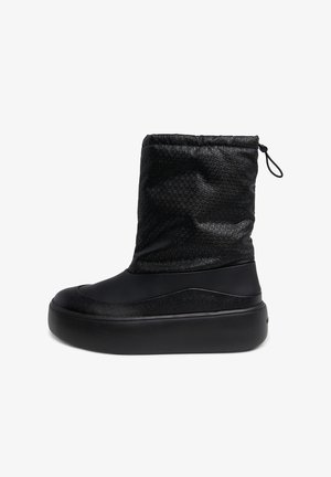 Botín negro hasta el tobillo con parte superior texturizada, cierre de cordón, suela de goma lisa y diseño de punta redonda.